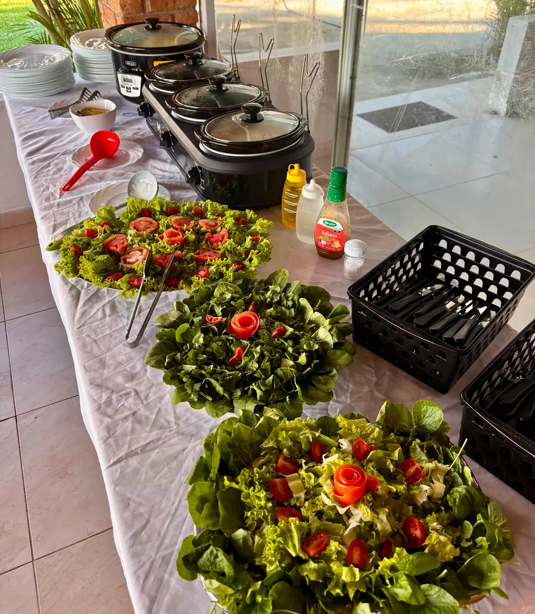 Mesa de buffet com saladas, massas e réchauds de pratos quentes